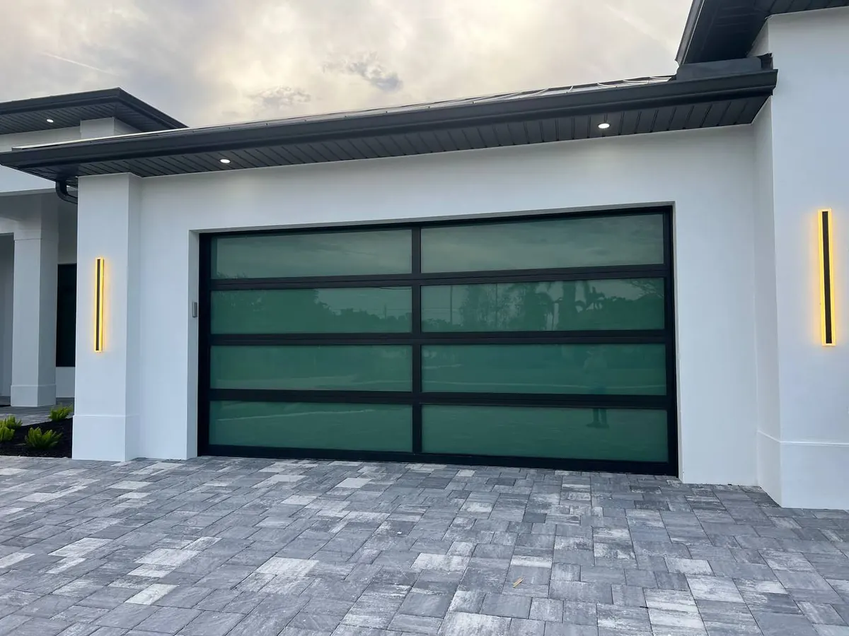AA Impact black frame full view glass door on a white Florida home with a paver drive