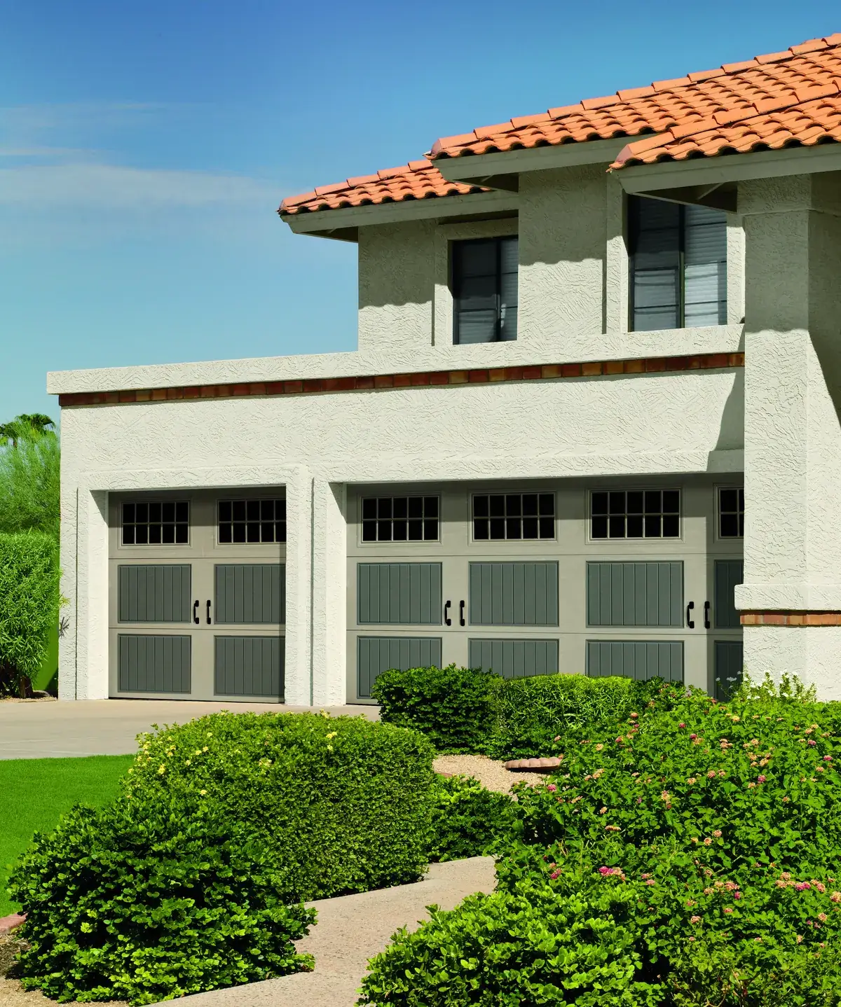 Amarr Classica carriage doors on a Mediterranean style stucco home with a tile roof
