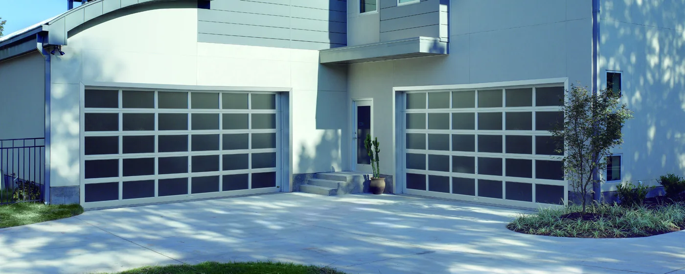Full view aluminium and glass garage doors on a modern white building