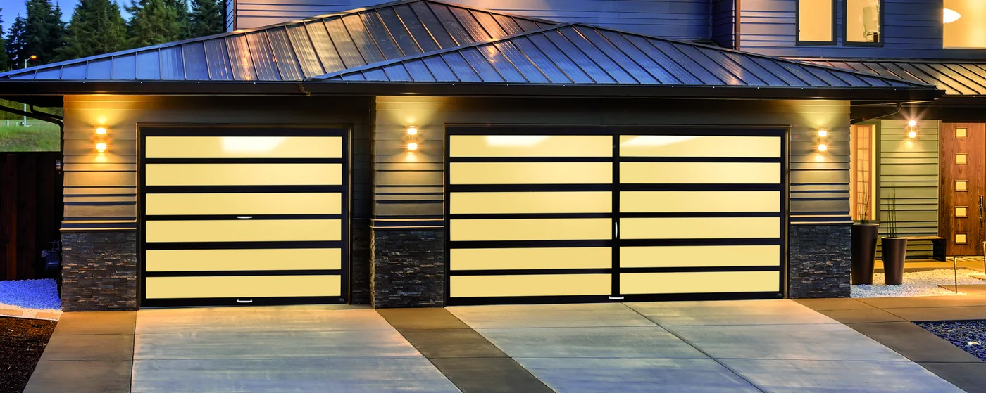 Full view aluminium and glass garage doors lit from inside at night