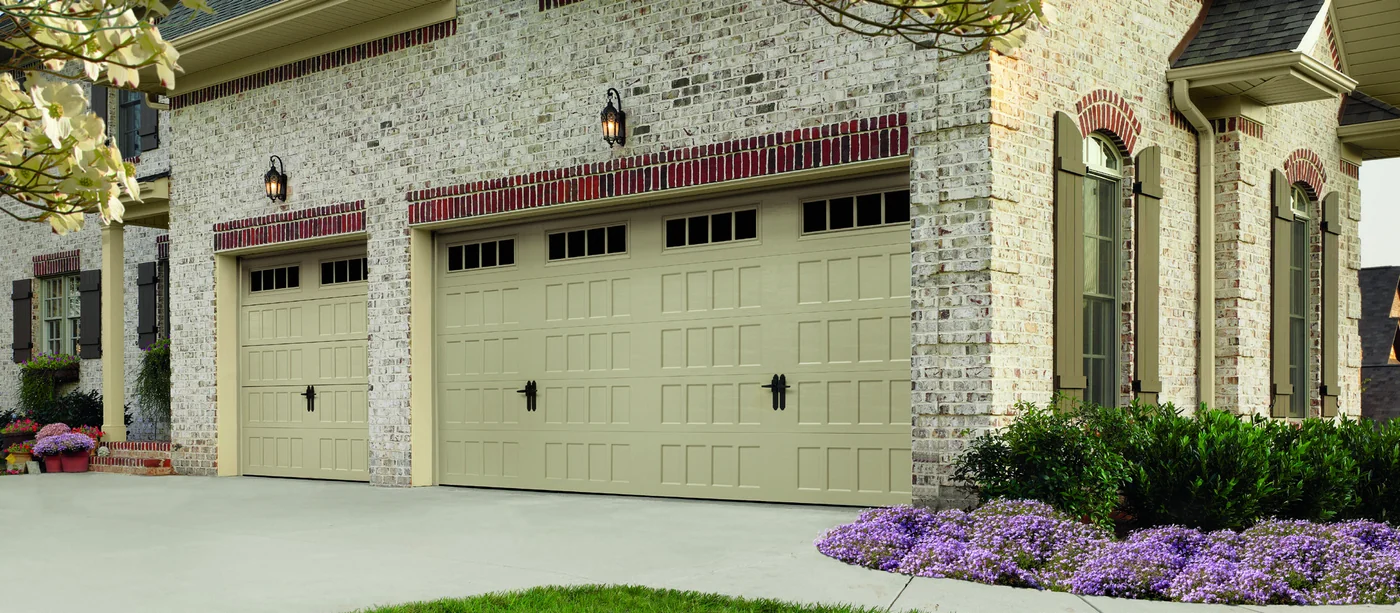 Amarr Hillcrest carriage house doors in almond with arched window inserts