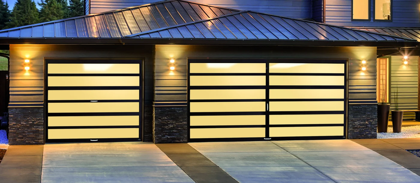 Amarr Horizon full-view aluminium and glass doors lit from inside at dusk