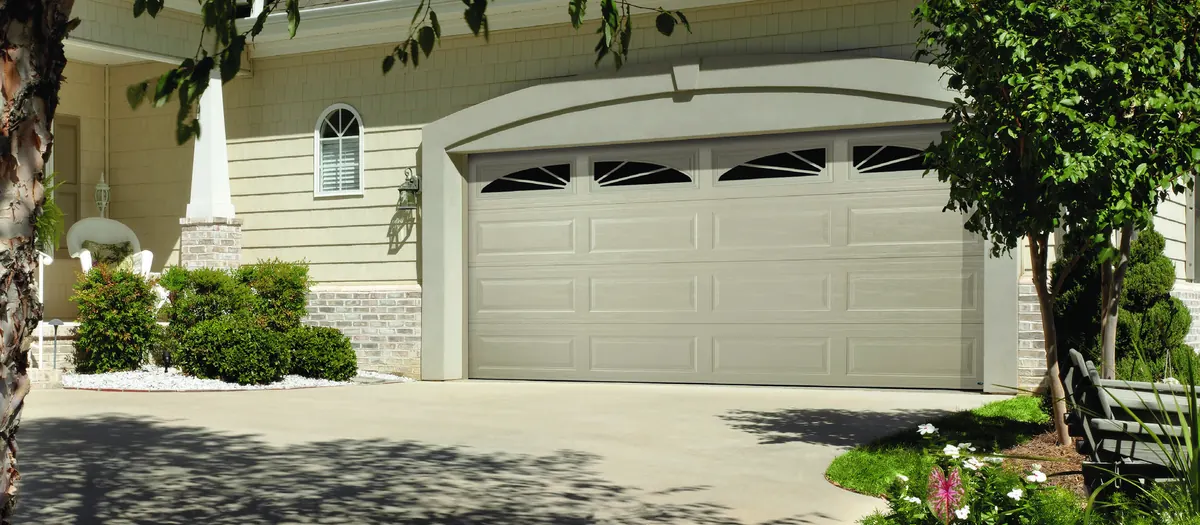 Cream Amarr Olympus raised panel door with an arched window row on a stucco home