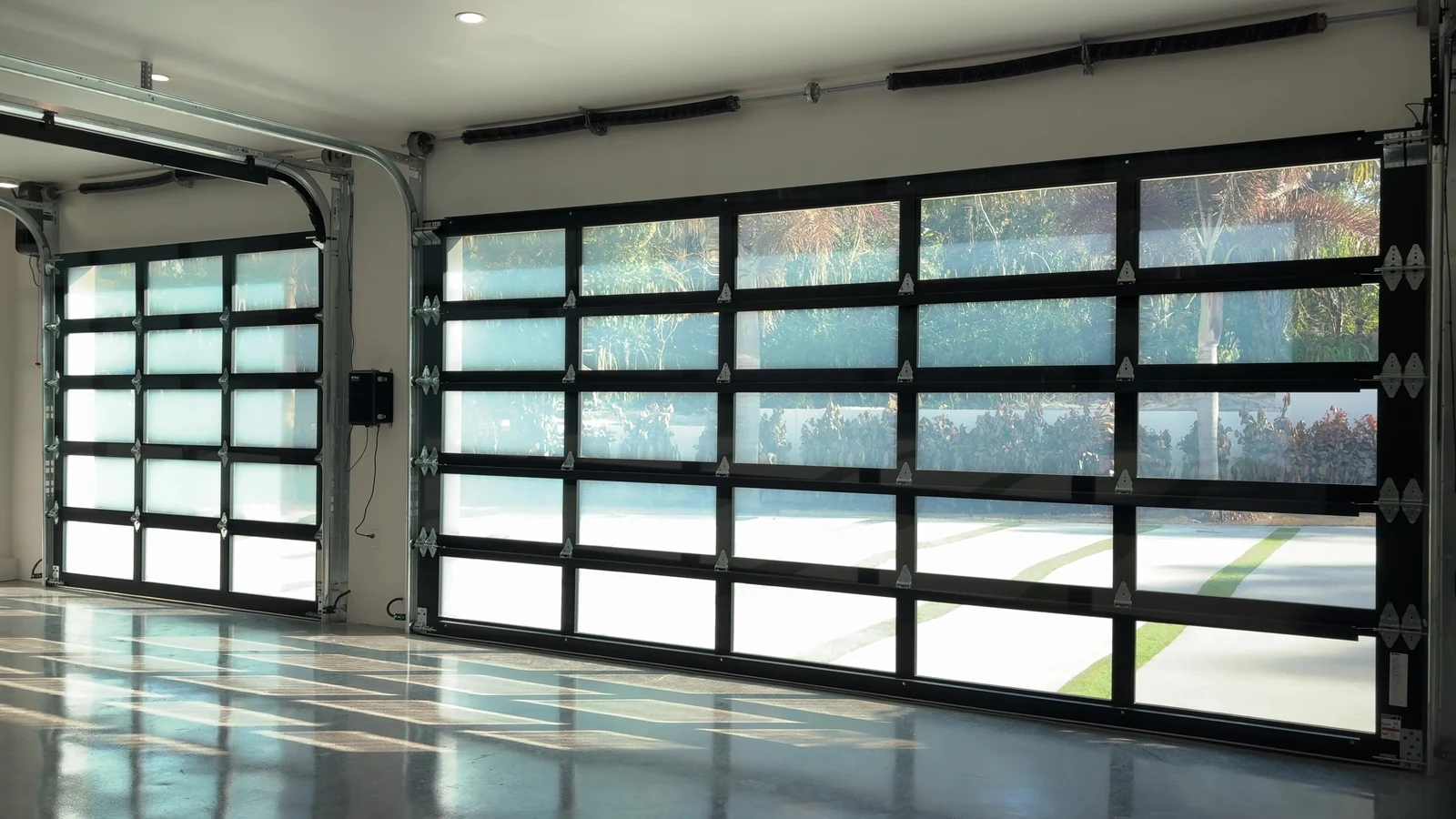 Full view glass garage door from inside, daylight through the frosted panels onto a polished floor