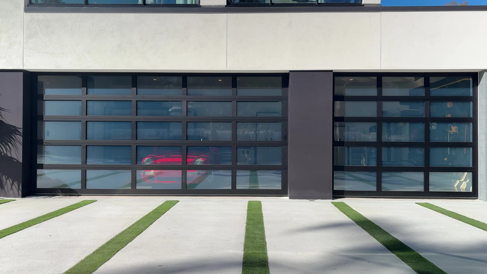 Two bays of full view glass garage doors across the front of a contemporary Florida home