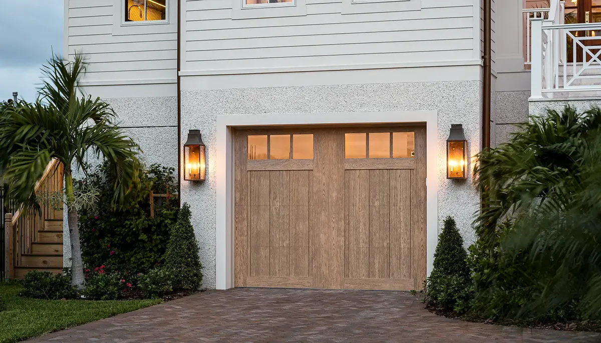 Clopay Canyon Ridge five layer carriage house door in a wood look on a white home