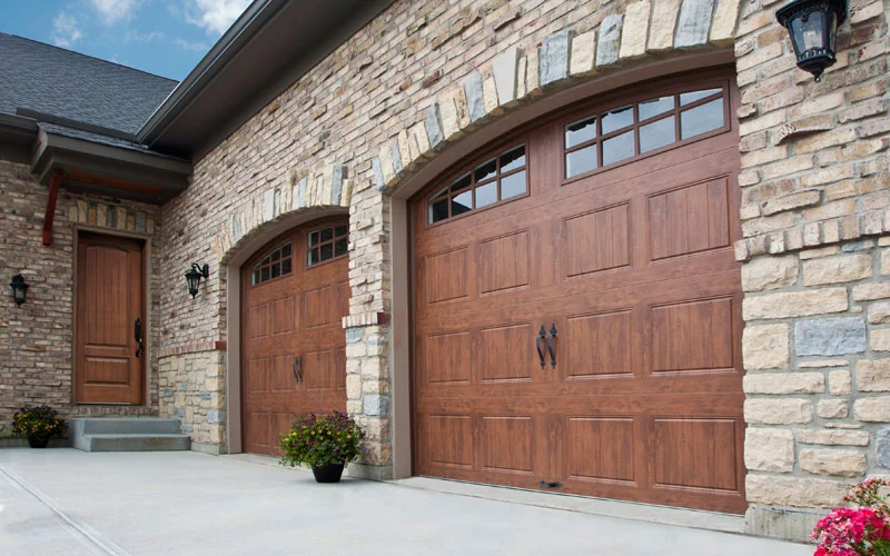 Gallery wood look door on a stone faced home with an arched surround