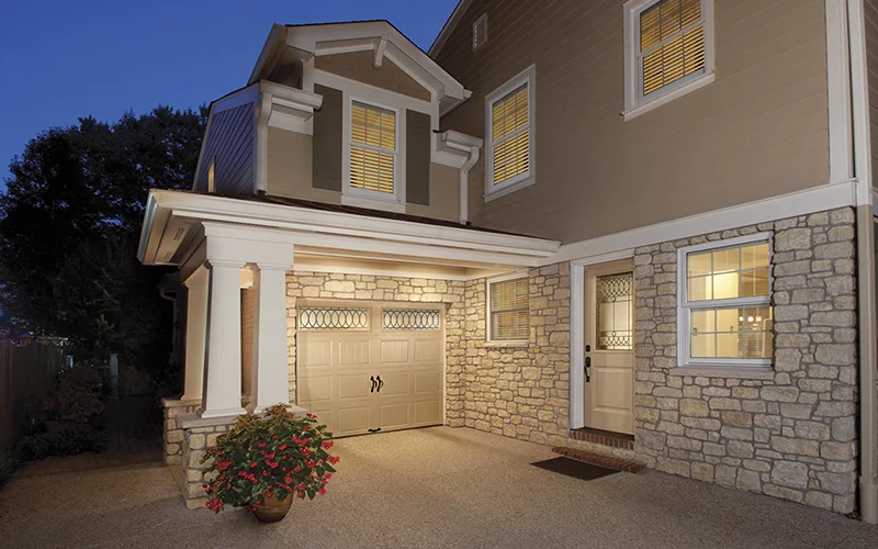 Clopay Gallery steel door on a beige stucco home with a stone surround