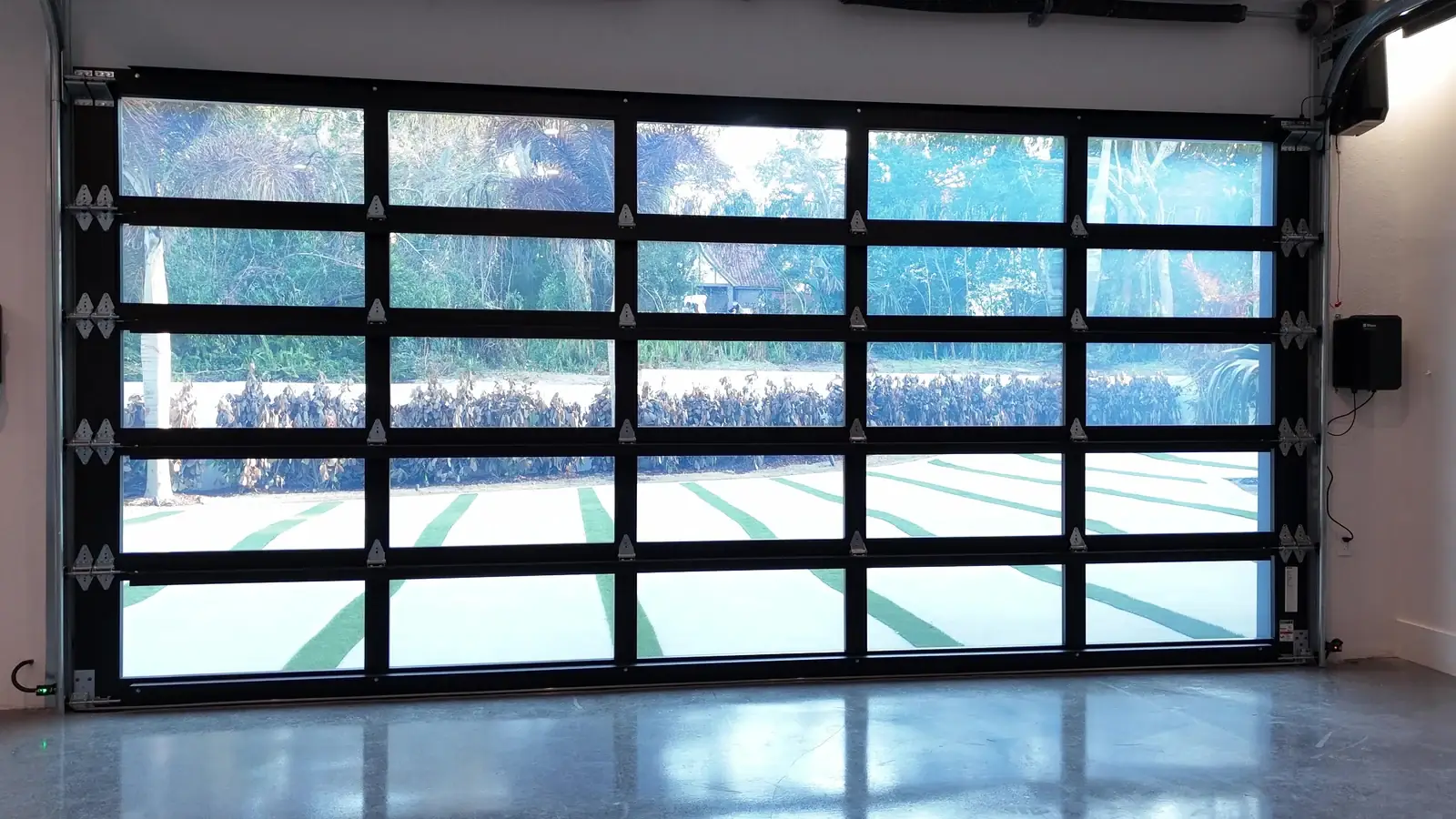 Full view glass garage door from inside with daylight flooding the bay
