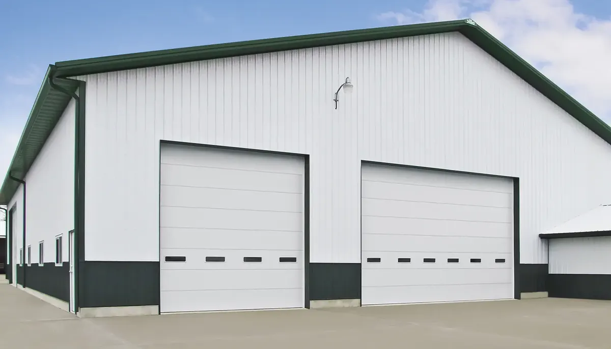 Two Clopay industrial ribbed steel doors on a white metal building