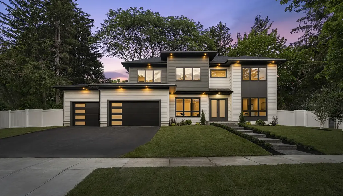 Clopay Modern Steel flush doors with window rows on a contemporary home at dusk