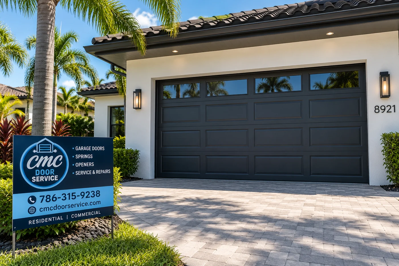 CMC Door Service yard sign beside a black garage door on a white Florida home with palms and a paver driveway