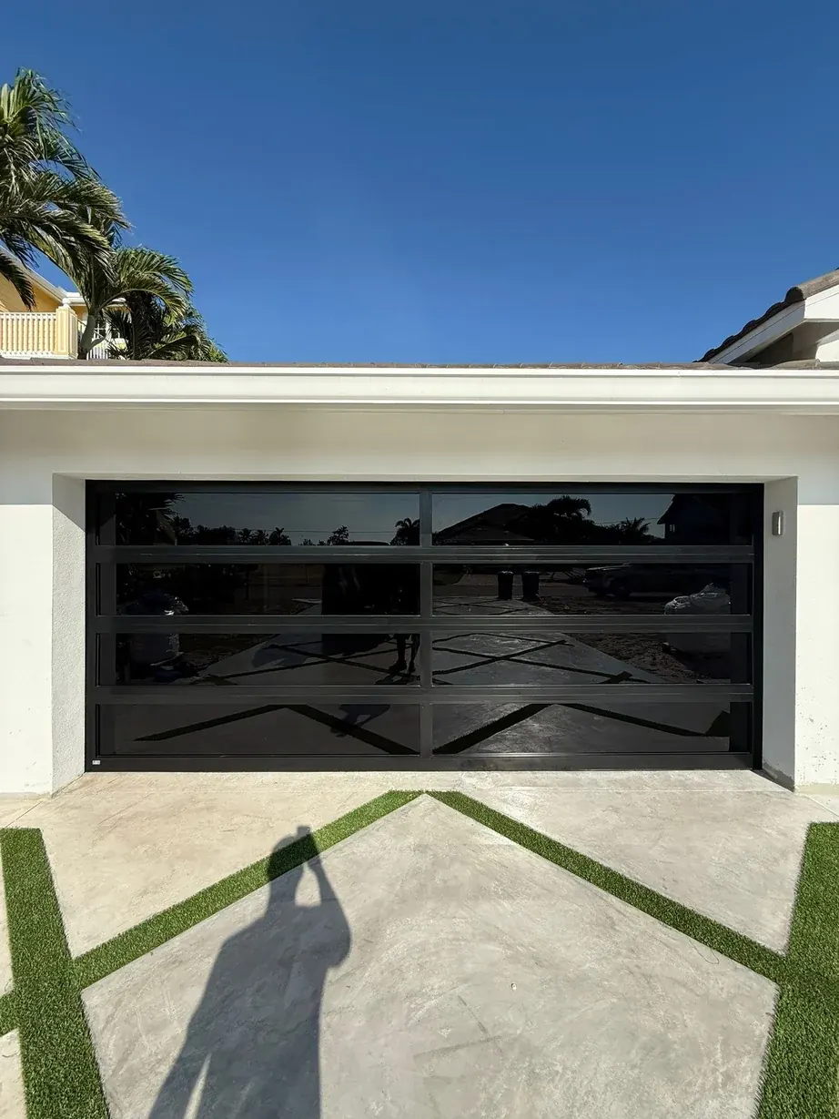 AA Impact Series 1600 two lite impact glass garage door, black frame and dark glass on a white home