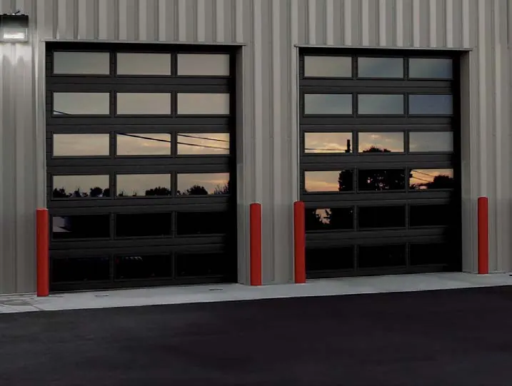 Clopay Architectural steel 3728 door, two dark doors with full window sections on a ribbed metal building at dusk. From the Model 3728/3729 data sheet