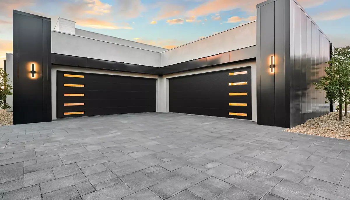 Clopay Modern Steel garage door, modern Steel doors in black with lit window strips, on a white modern house