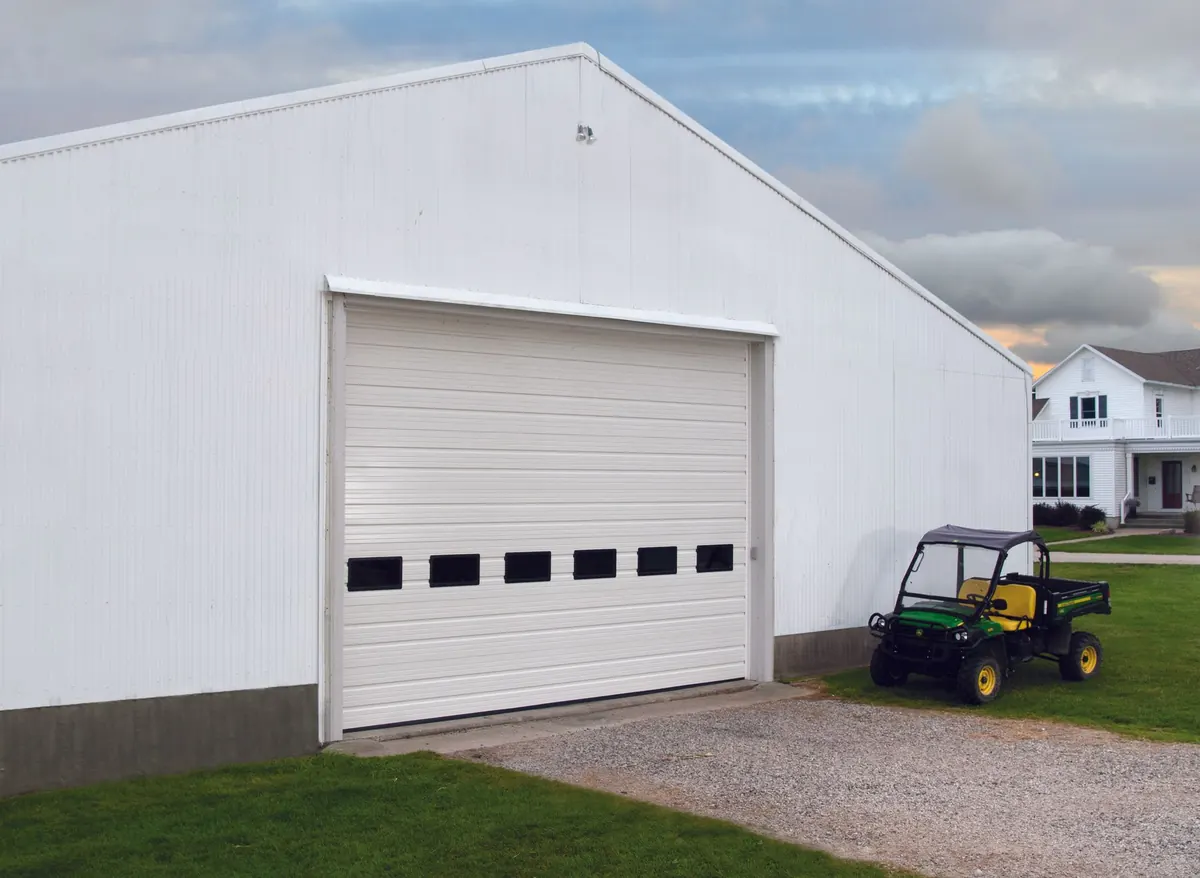 Haas Door Ribbed steel commercial door, haas C2511 ribbed steel door in White with a row of lites on a white farm building