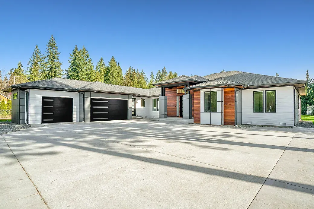 Puerta de garaje Raynor Aspen Contempra, puertas negras con ventanas delgadas en una casa moderna tipo ranch