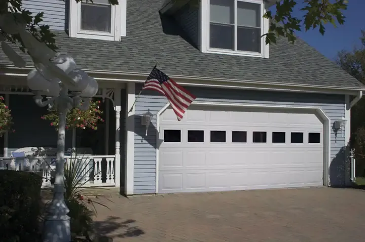Raynor BuildMark garage door, white door with a row of windows on a sided home
