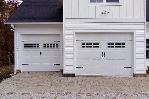 Puerta de garaje Raynor BuildMark, dos puertas blancas estilo cochera con ventanas y manijas