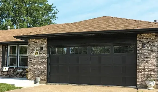 Puerta de garaje Raynor Country Manor, puerta doble negra con una fila de ventanas en una casa de ladrillo