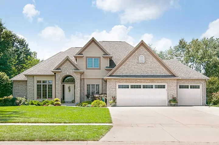 Raynor LuxeVue garage door, white door with a tall row of windows on a brick home