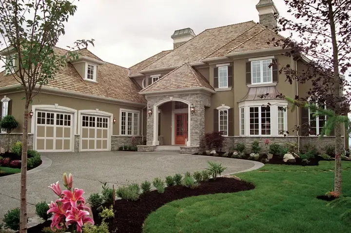 Raynor StyleView garage door, two white framed glass doors on a stone home