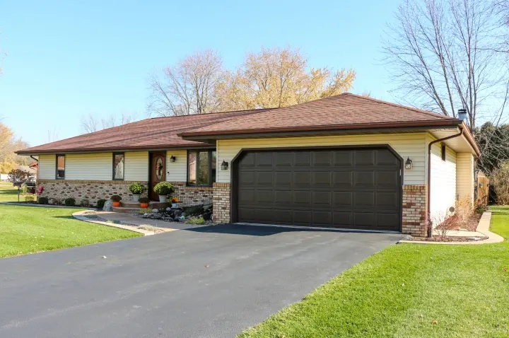 Raynor TradeMark garage door, dark brown double door on a ranch home