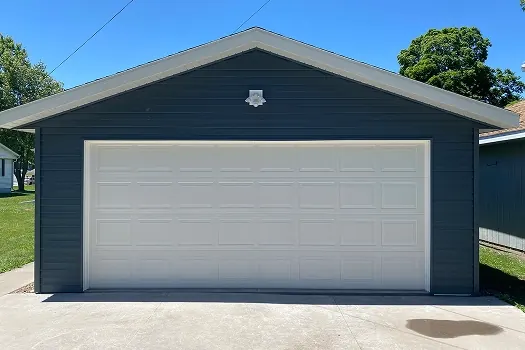 Puerta de garaje Raynor TradeMark, puerta doble blanca de paneles realzados en un garaje azul marino