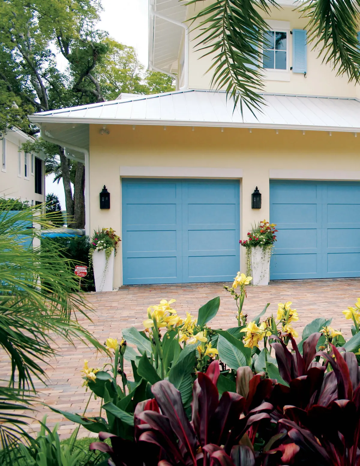Blue Eden Coast doors on a cream Florida home with palms and tropical planting