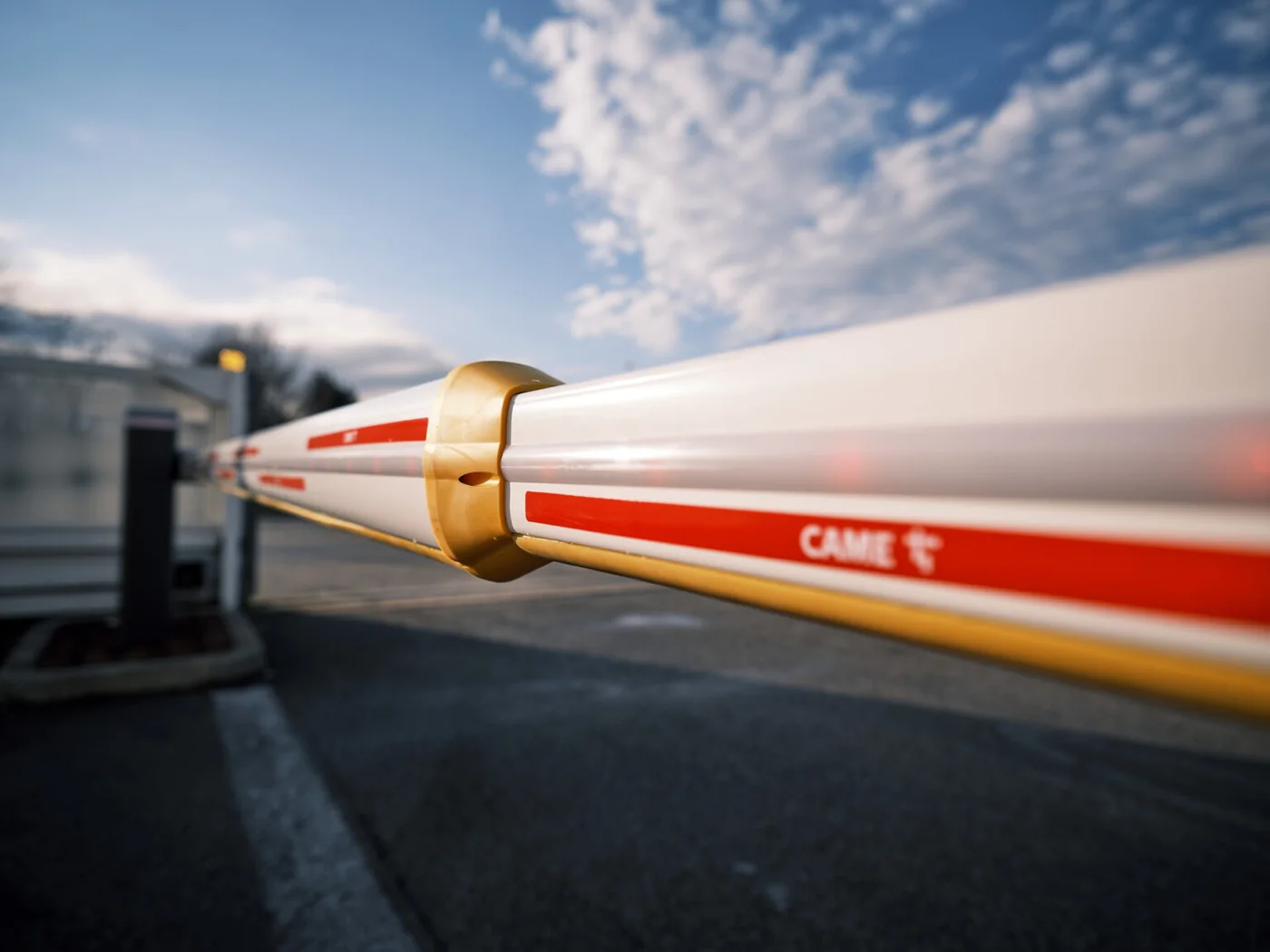A barrier arm rising against an open sky