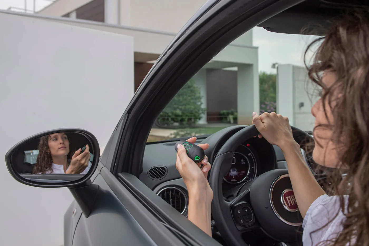 A driver reaching out to a gate reader from the car window