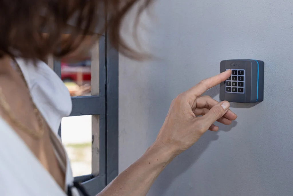 Entering a code on a keypad mounted at a driveway gate post