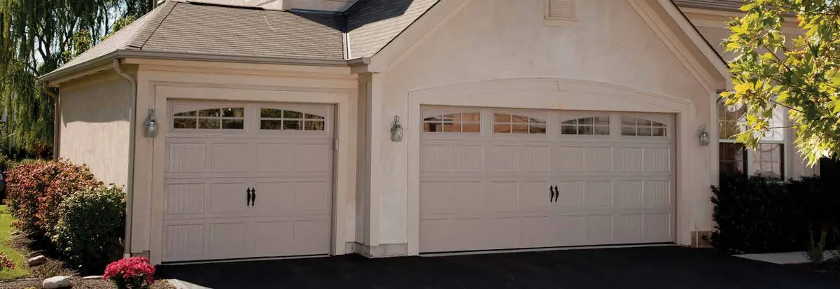 Cream Haas 2000 series doors with window rows on a stucco two car garage
