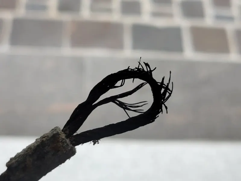 Broken garage door lift cable with frayed strands