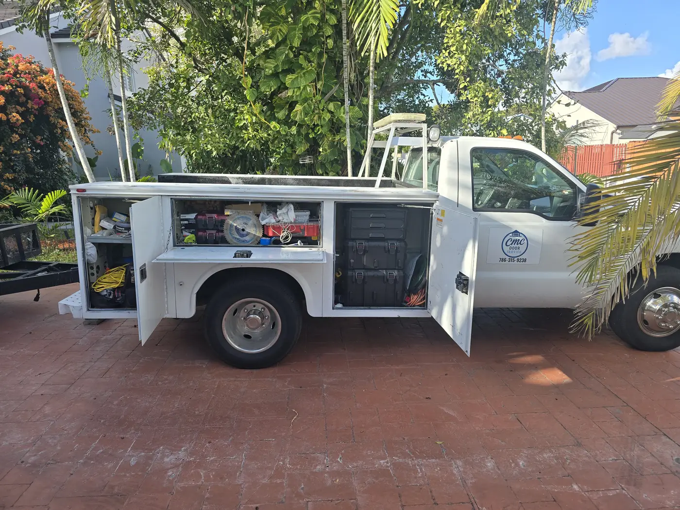 The CMC Door Service truck with its bin doors open, showing the tools, spares and cable stock carried to every call