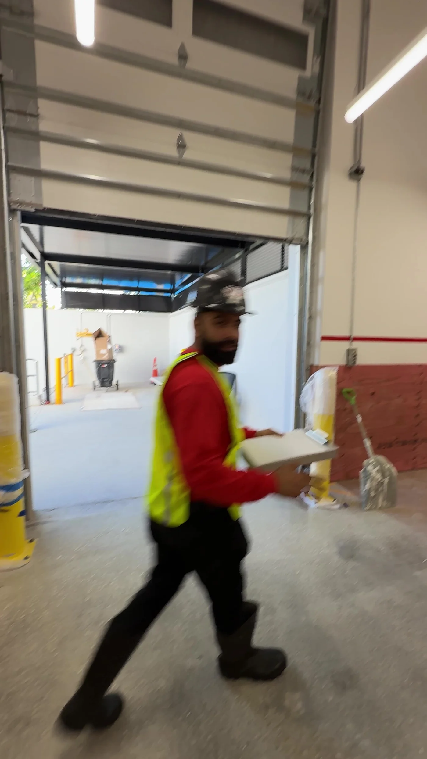A CMC technician crossing a tall commercial door bay during a fit out