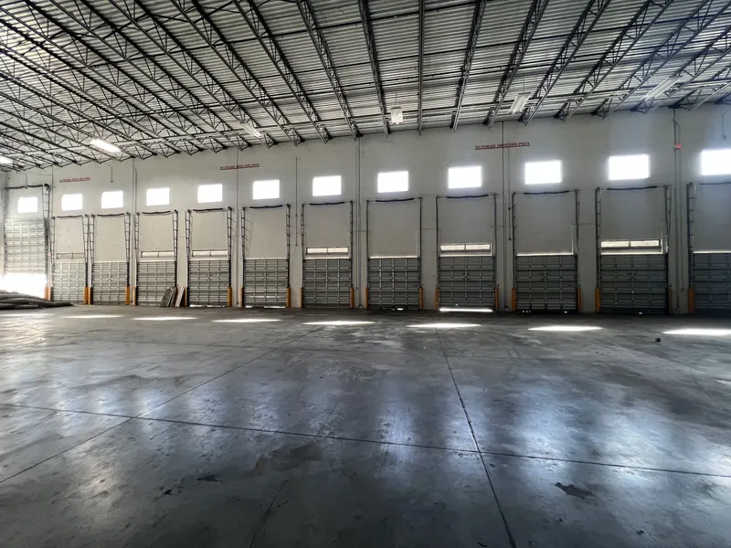 A white commercial sectional door on a warehouse elevation