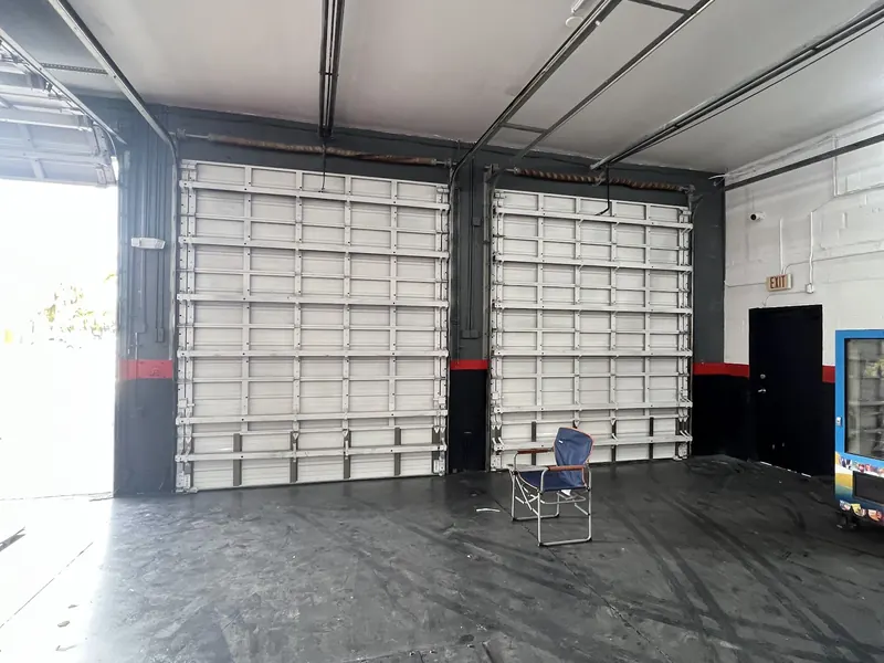 A wide white commercial door on a workshop building