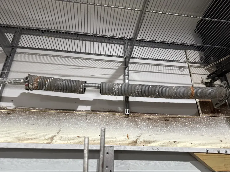 Twin torsion springs on the shaft of a commercial sectional door
