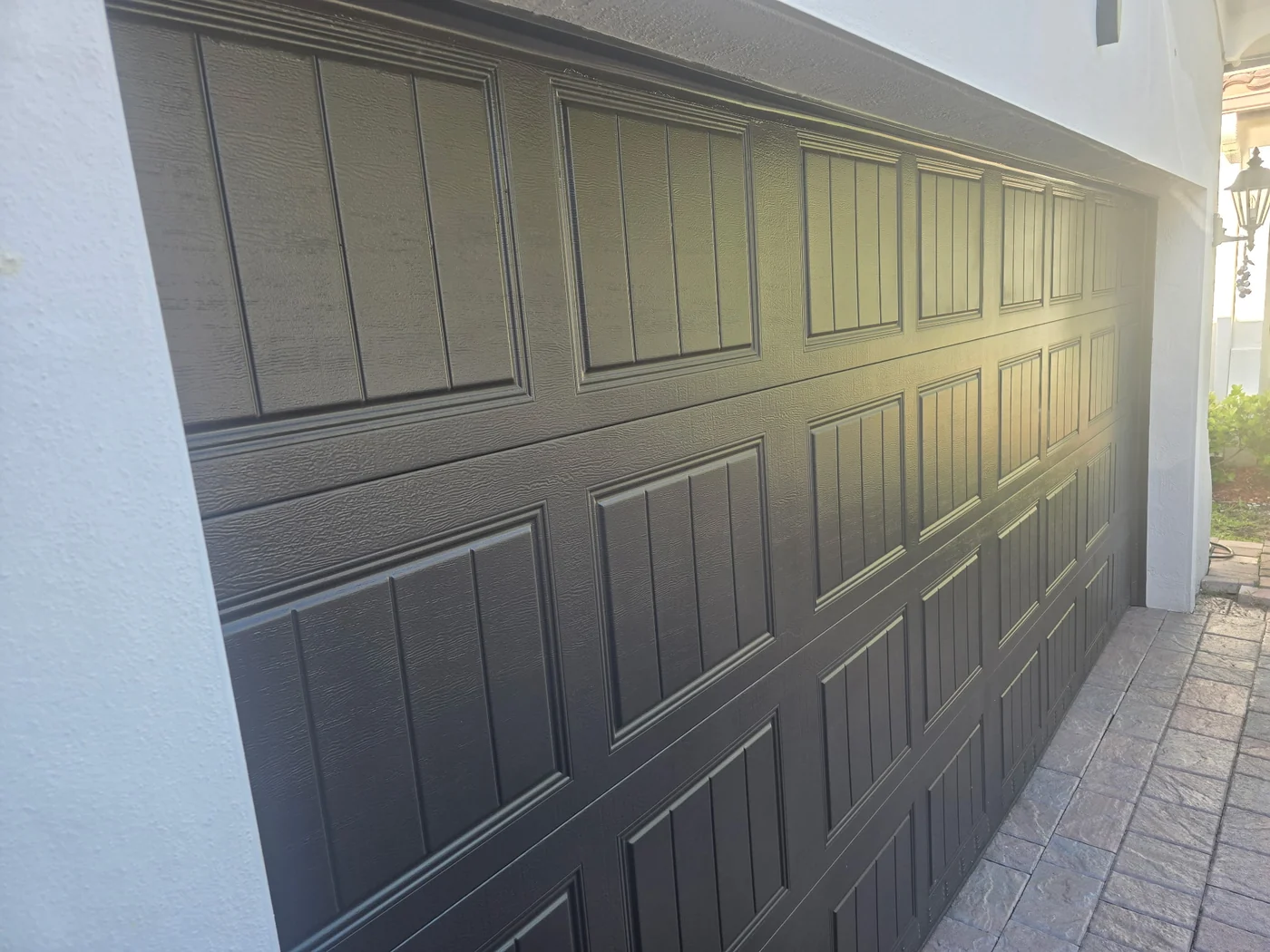 Dark brown carriage-style raised panel garage door installed by CMC Door Service on a Miami home