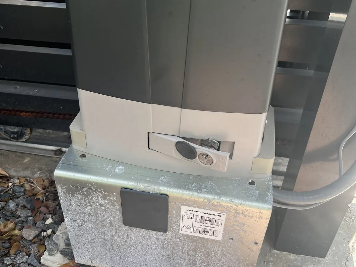Beninca slide gate operator mounted on its galvanized base plate at the gate track