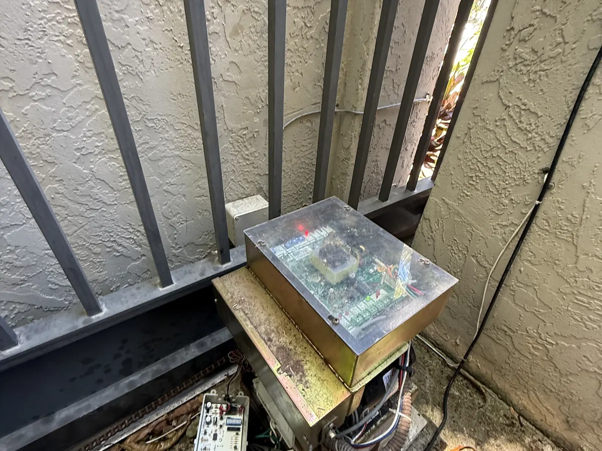 Corroded gate operator cabinet opened against a stucco wall, the condition that gets an enclosure replaced rather than repaired