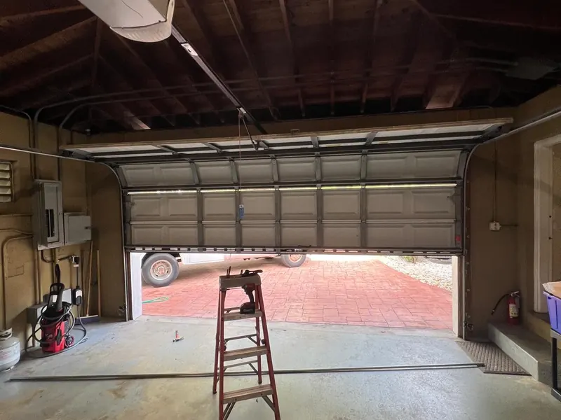 Garage door opener mounted to a wood framed garage ceiling