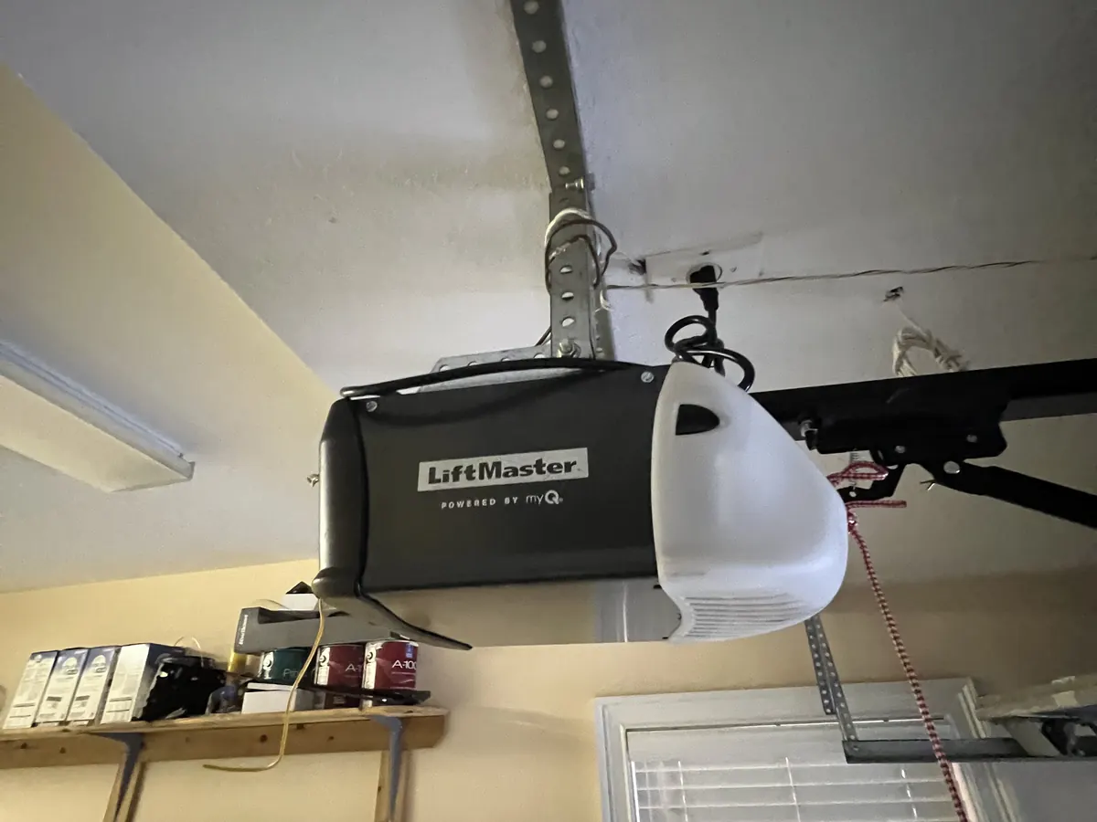 A LiftMaster belt drive opener with myQ mounted to a garage ceiling, its rail running back to the door