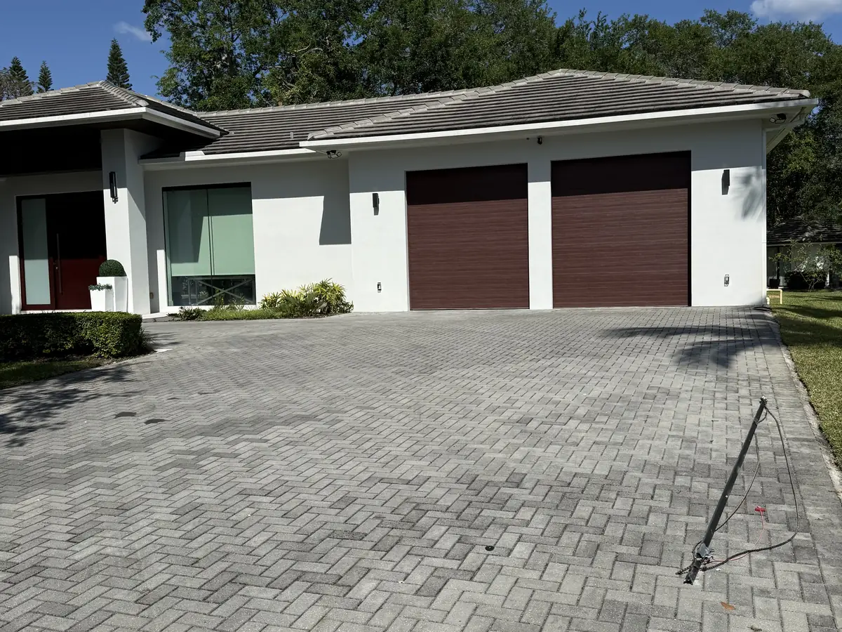Two single car flush panel garage doors in a mahogany finish on a low modern house