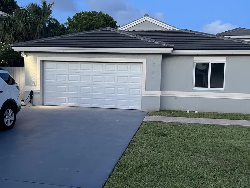 White flush panel single garage door on a one story home