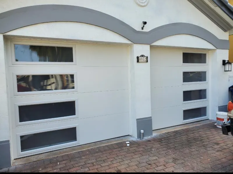 Puertas de garaje blancas de panel liso con una columna de ventanas verticales