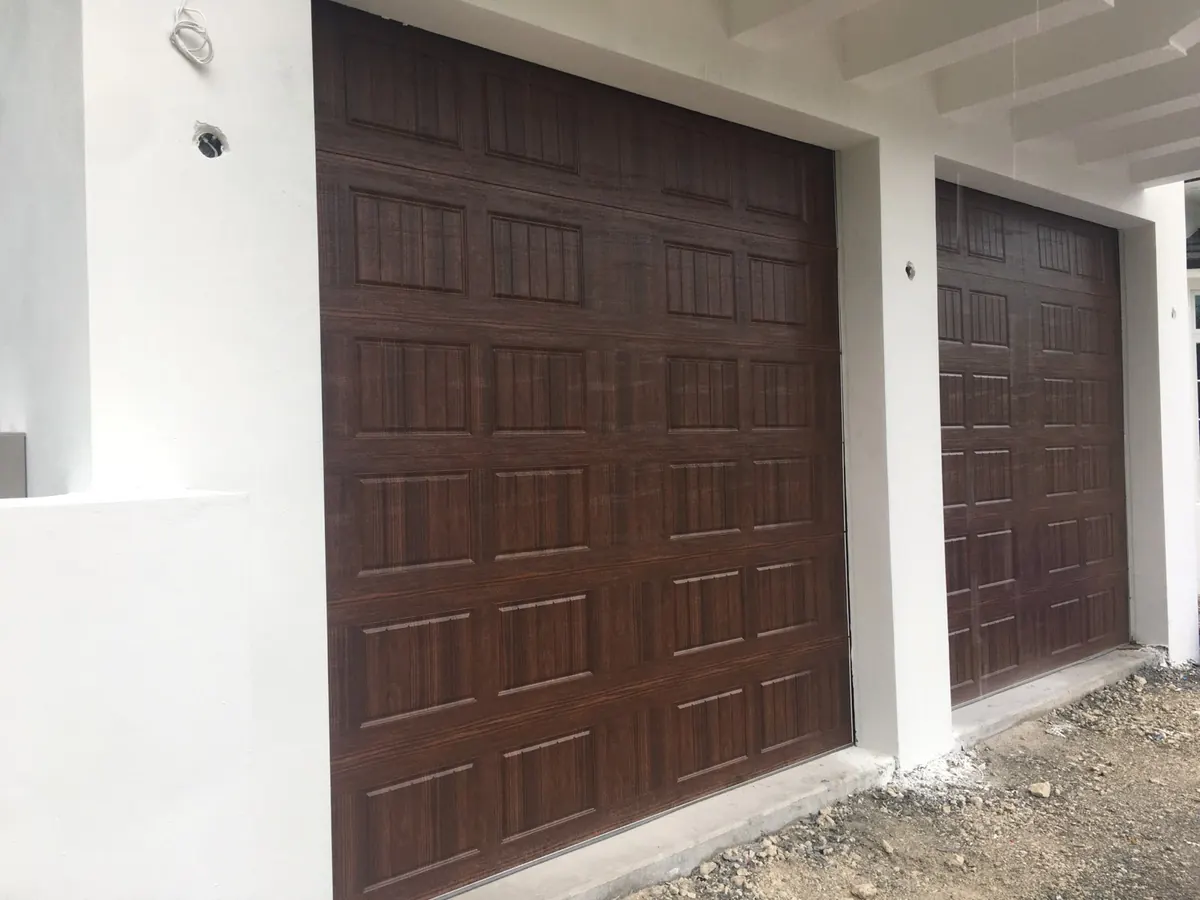 Walnut woodgrain raised panel doors, one double and one single, on a white stucco elevation