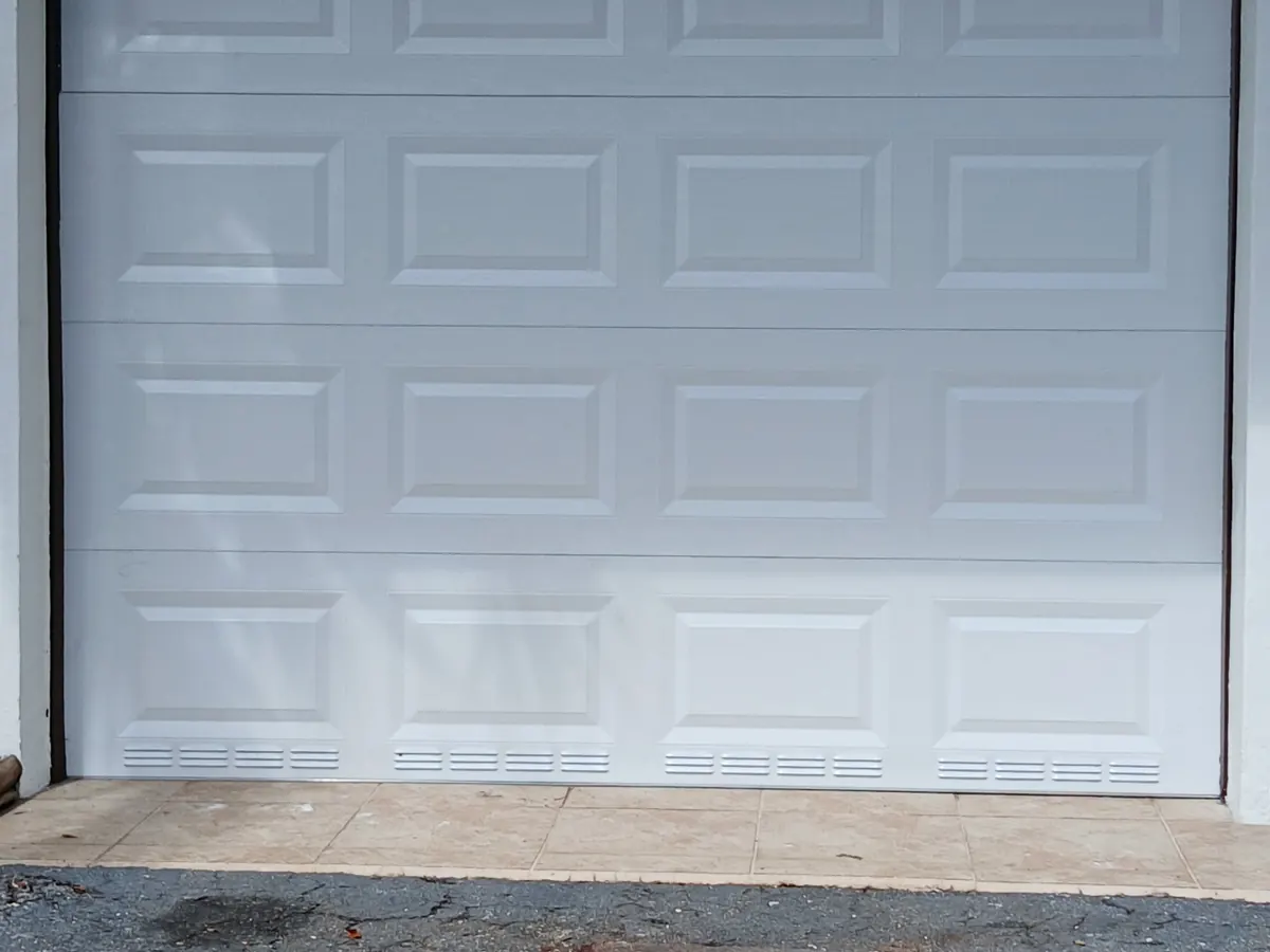 White short panel sectional garage door closed on a plain rendered elevation