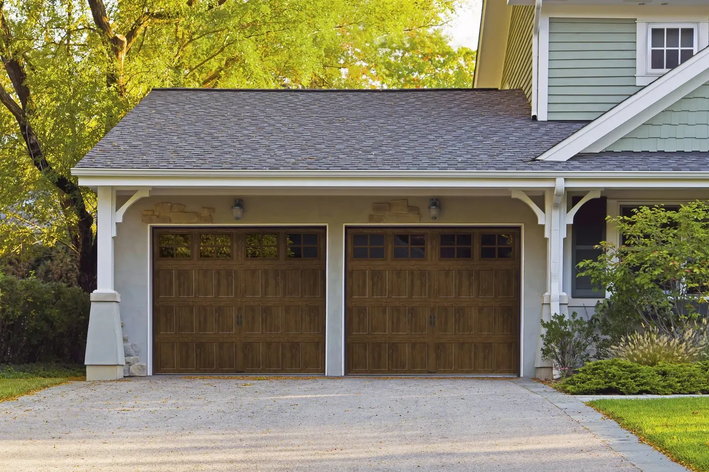 Wood-look double garage door installed by CMC Door Service on a South Florida home